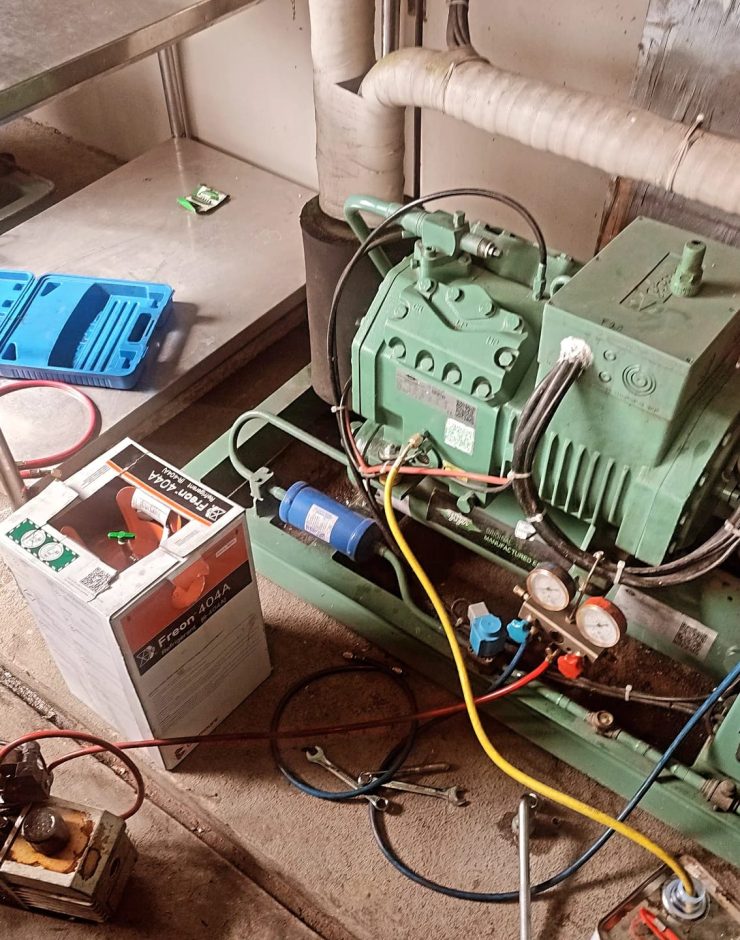 Technician performing preventive maintenance on a commercial cold room refrigeration system in Kenya