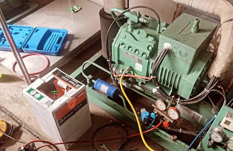 Technician performing preventive maintenance on a commercial cold room refrigeration system in Kenya