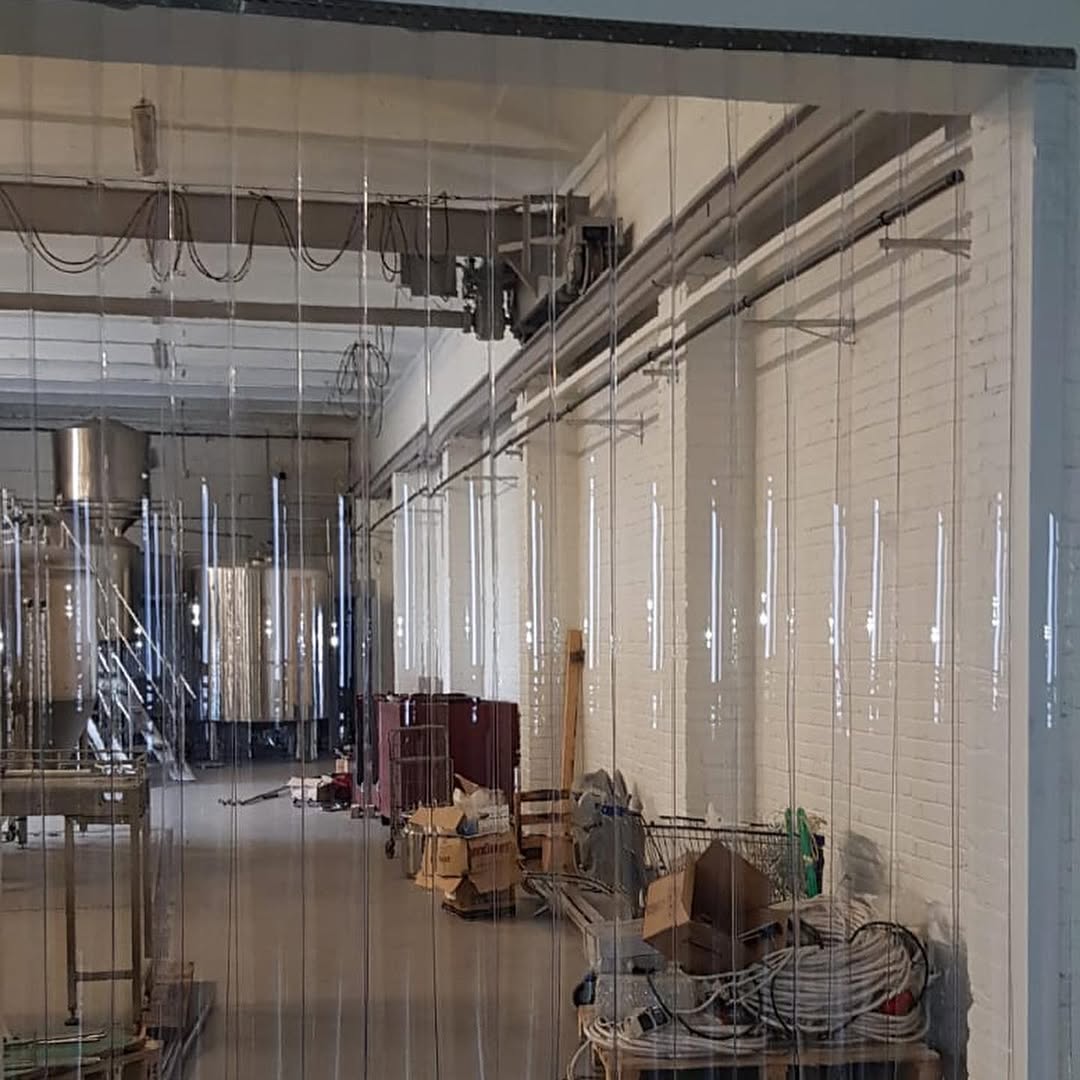 Clear PVC strip curtain installed across a facility doorway
