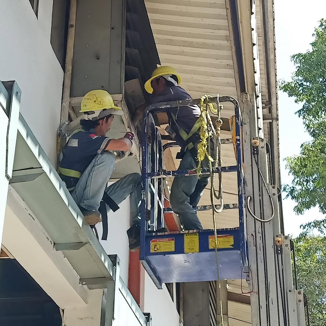 Two technicians installing an evaporator fan unit inside a cold room