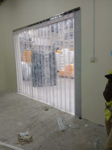 Overlapping PVC strip curtains fitted at a cold room entrance